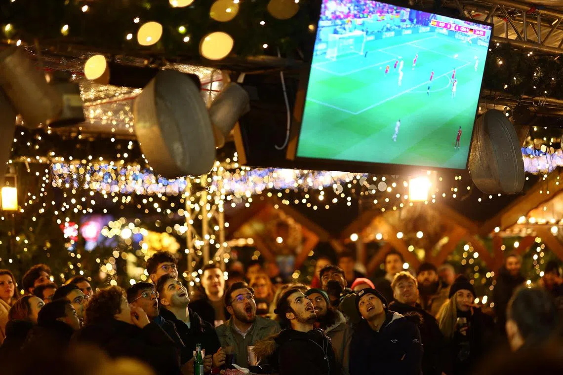 Fans watch the match between Spain and Germany in Breitscheidplatz's Christmas Market in Berlin.