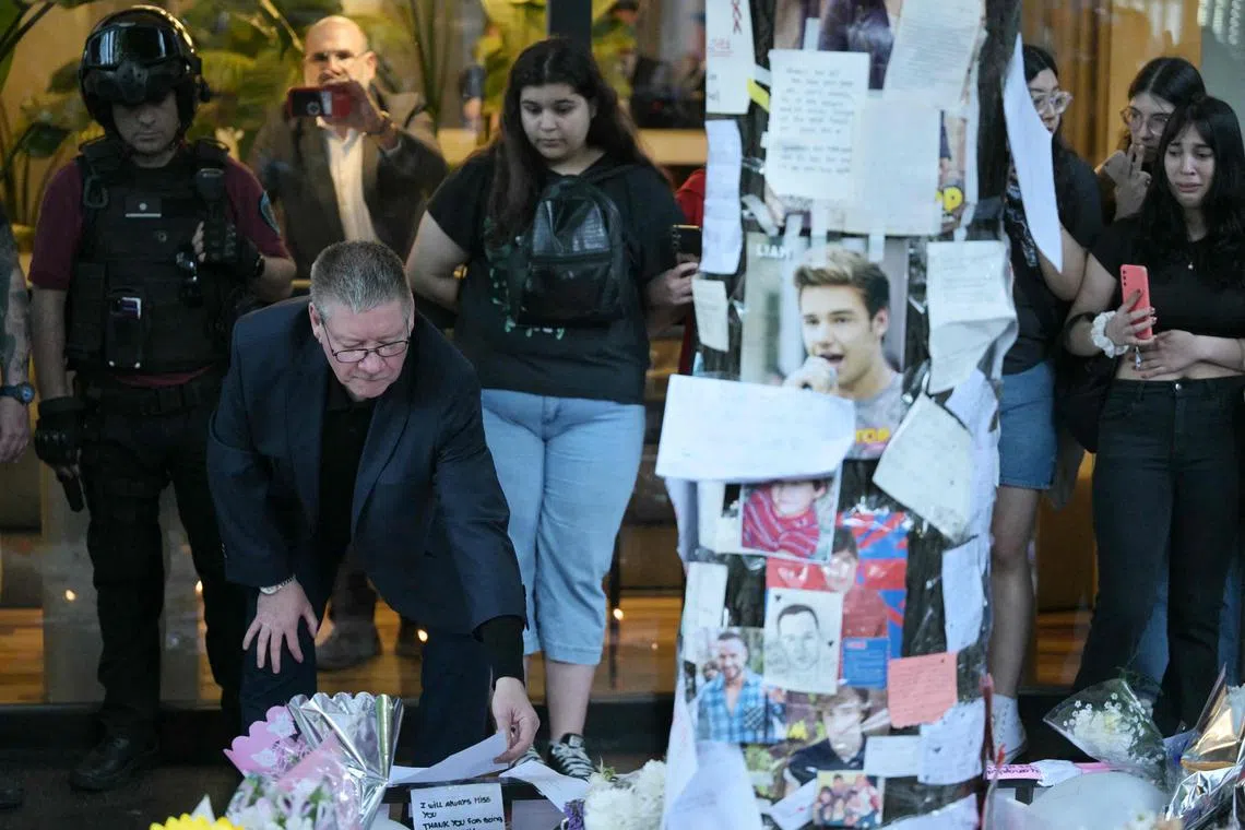 Liam Payne's father, Geoff (left), looks at tributes to his son, at a memorial outside the CasaSur Hotel in Buenos Aires, on Oct 18.