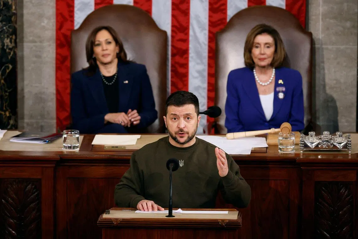 Vice President Kamala Harris (left) and Speaker of the House Nancy Pelosi (right) listen to Ukranian President  Volodymyr Zelensky address the Congress in the House Chamber of the US Capitol on Dec 21, 2022.