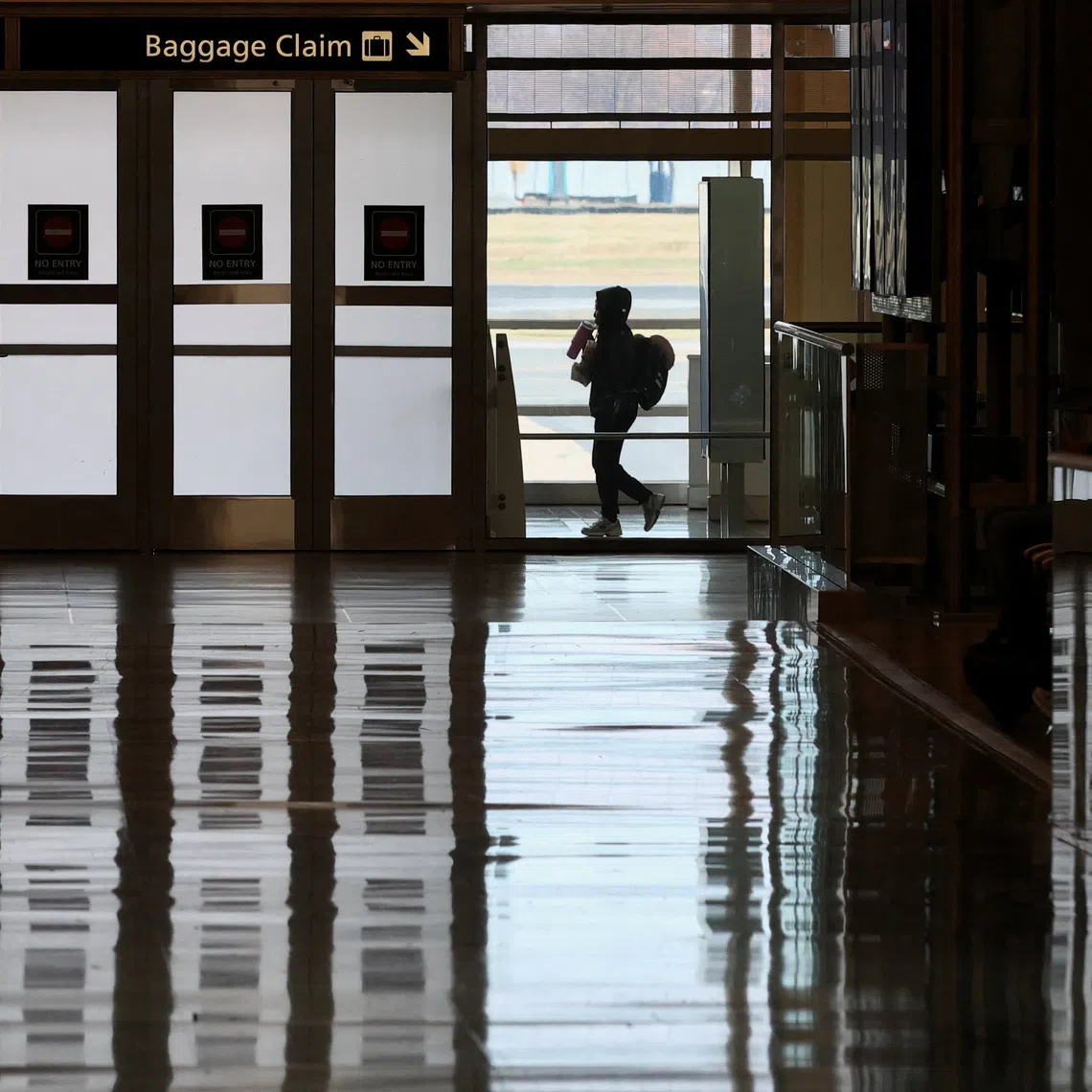 A passenger walks in the terminal at Ronald Reagan Washington National Airport on the busiest travel day of the Thanksgiving holiday, in Arlington, Virginia, U.S., November 25, 2025. REUTERS/Kevin Lamarque