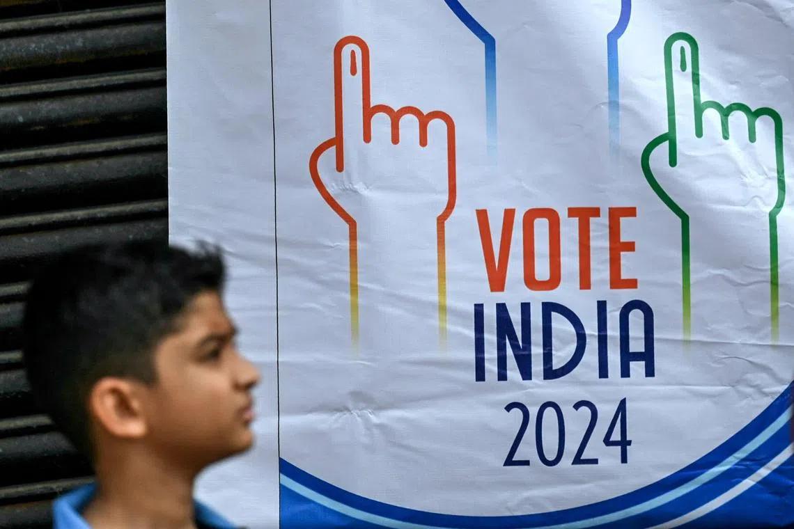 A boy walks past a banner during a students rally to create awareness about the importance of voting, ahead of the upcoming general elections, in Chennai on March 9, 2024. (Photo by R.Satish BABU / AFP)