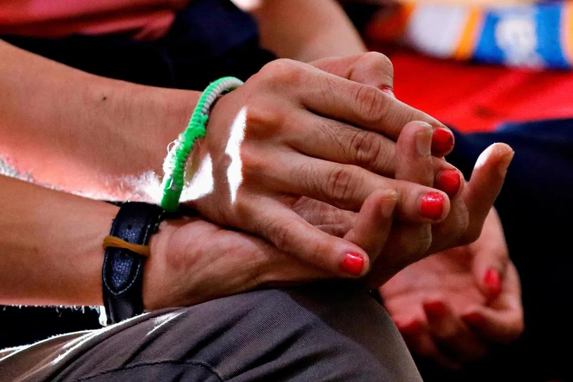 Chika, a 28-year-old trans woman, holds her boyfriend's hand during an interview at their rented room in Jakarta.