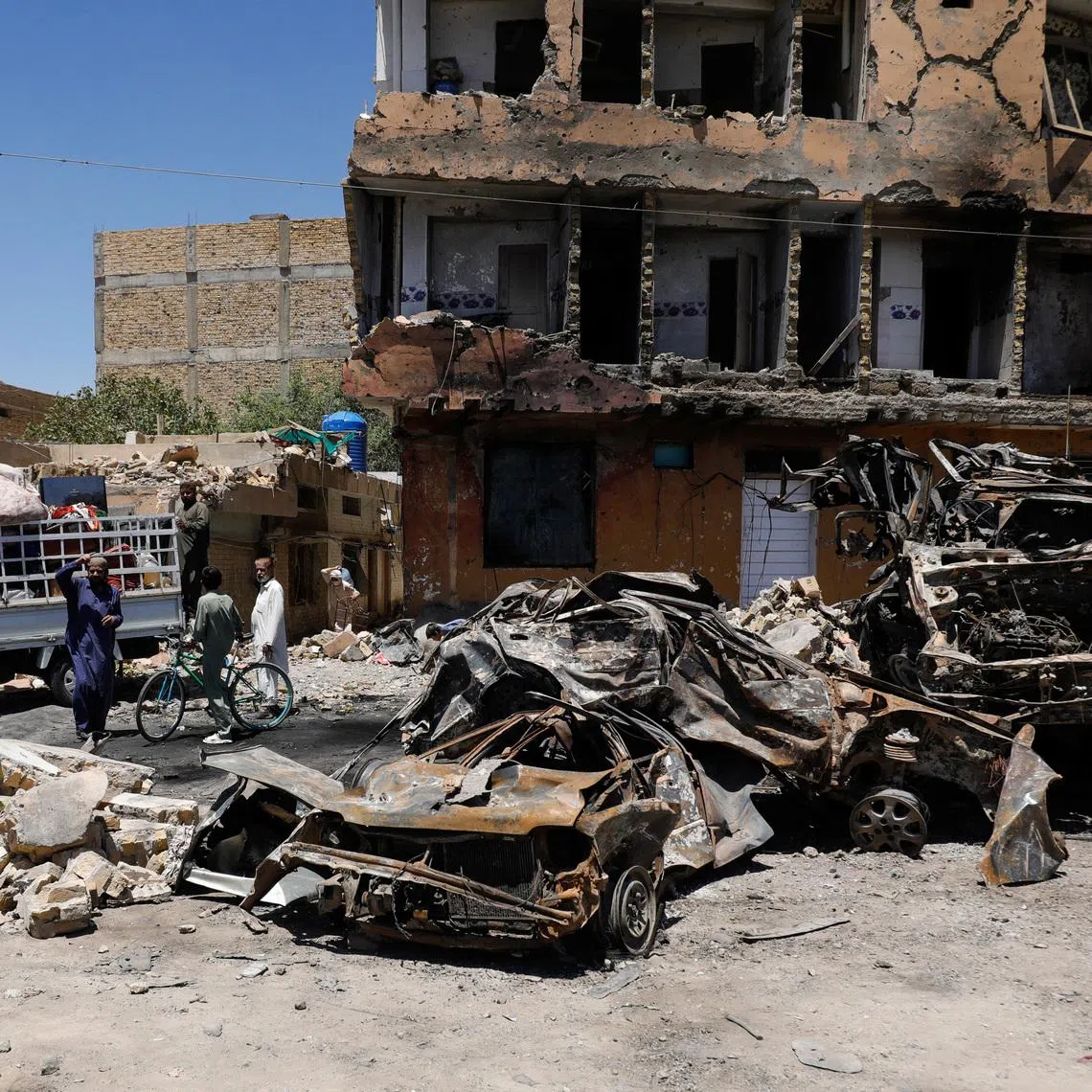 Residents stand next to a damaged building, rubble and destroyed cars a day after a blast in Quetta, Pakistan May 25, 2026. REUTERS/Naseer Ahmed