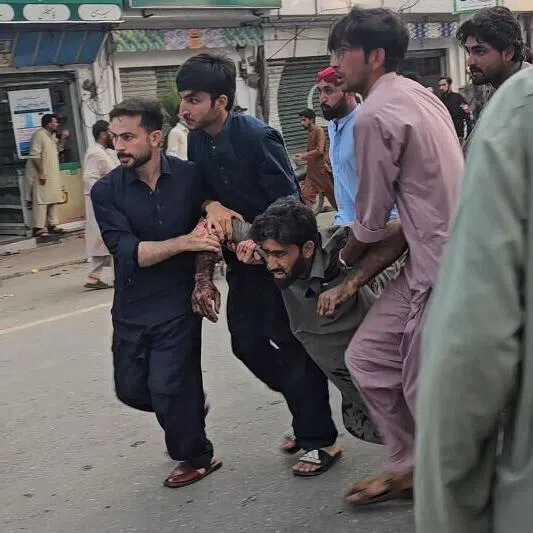 People evacuating an injured victim after a suicide bombing during a protest in Pakistan’s Swat district on Aug 2.