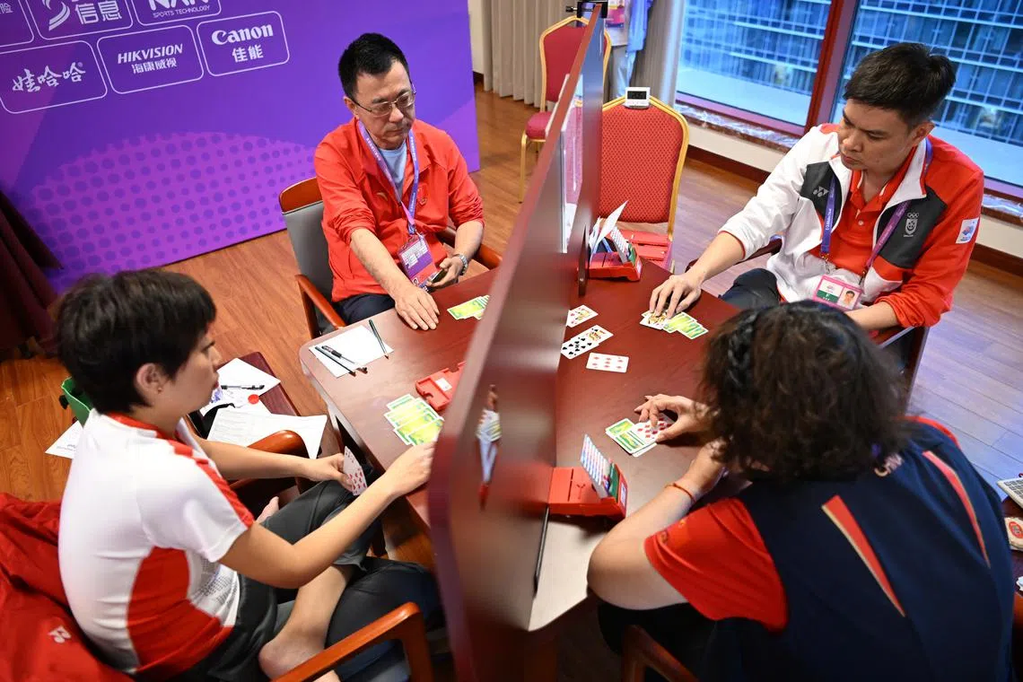 Lam Ze Ying (left) and Loo Choon Chou (far right) of Singapore in action during the bridge mixed team semi-final against China.