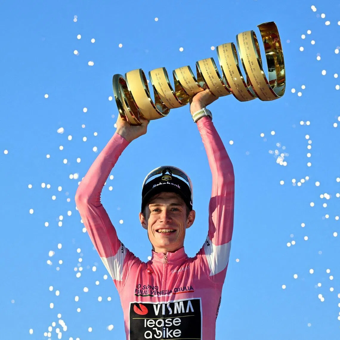 Team Visma-Lease a Bike's Jonas Vingegaard celebrates on the podium with the trophy, wearing the maglia rosa jersey, after winning the Giro d'Italia on May 31.