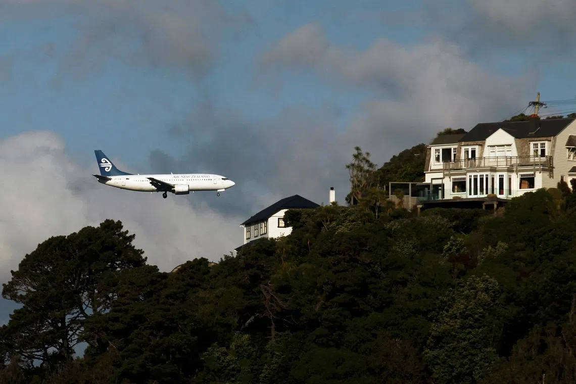 FILE PHOTO: An Air New Zealand plane flies over houses in Mount Victoria as it approaches Wellington airport, October 7, 2011.  REUTERS/Marcos Brindicci (NEW ZEALAND - Tags: TRANSPORT SOCIETY)/File Photo