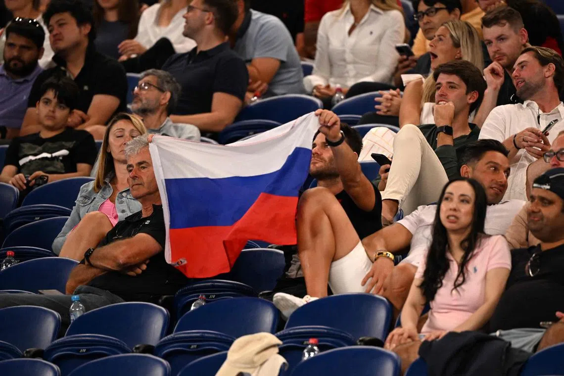 A supporter holds a flag of Russia during the men's singles match between Marcos Giron of the US and Russia's Daniil Medvedev on Monday at the Australian Open. 