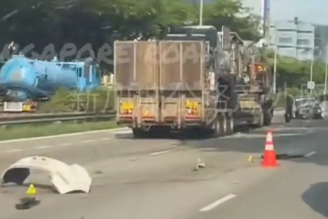 In videos that circulated on social media, a white bumper can be seen on the road just behind a stationary trailer which appears to be transporting a large construction machine. A white car with a mangled front portion is further ahead.