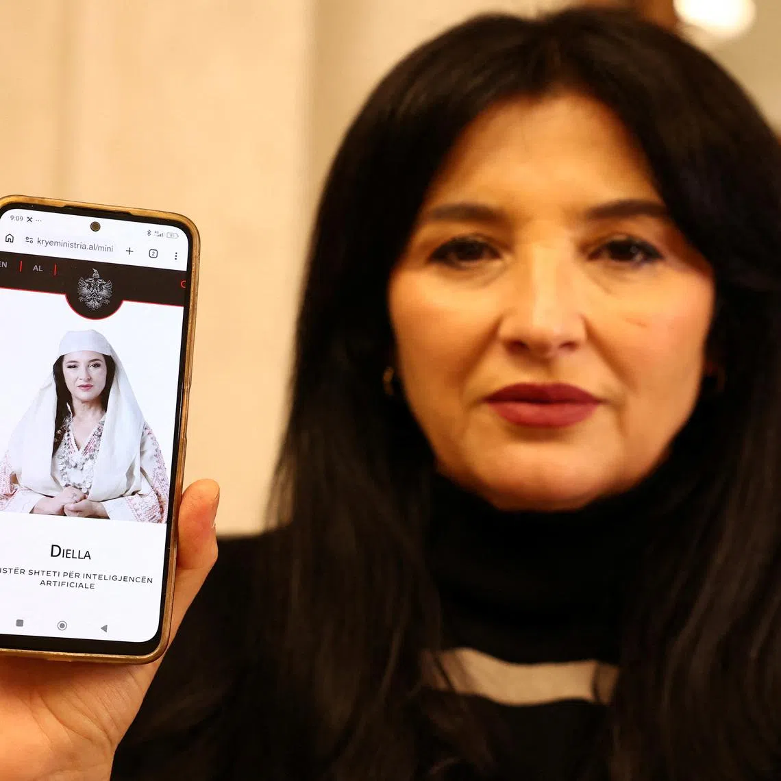 Albanian actor Anila Bisha, who is suing the government, claiming officials unlawfully used her face and voice to create an AI chatbot named Diella, presented as a \"virtual minister\", shows her phone displaying a govermental website, in Tirana, Albania, on February 12, 2026. REUTERS/Florion Goga