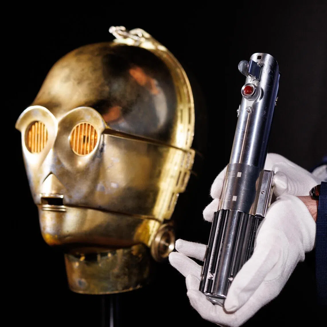 A Light-Up C-3PO Head and Hero Lightsaber Hilt featured in the Star Wars films are displayed by Propstore auction house in Rickmansworth, Hertfordshire, Britain, on Jan 30.