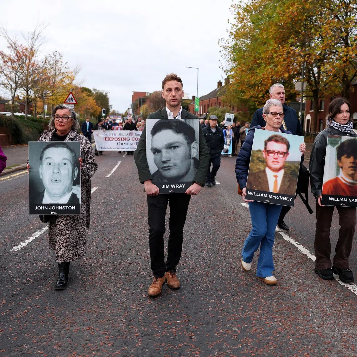 Family members hold pictures of victims of the 1972 'Bloody Sunday', as a judge is expected to give a verdict on the trial of the British army veteran known as 'Soldier F', charged with two murders and five attempted murders in relation to Bloody Sunday, in Belfast, Northern Ireland, October 23, 2025. REUTERS/Cathal McNaughton