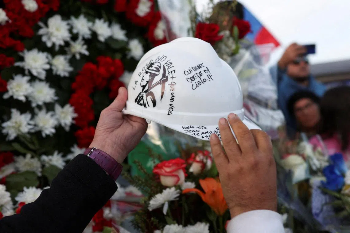 People hold a helmet during the funeral of Jean Miranda Ibaceta, one of the five miners of Chilean state-run copper producer Codelco who died after being trapped following a collapse at El Teniente copper mine, at a cemetery in Rancagua, Chile August 4, 2025. REUTERS/Pablo Sanhueza/File Photo