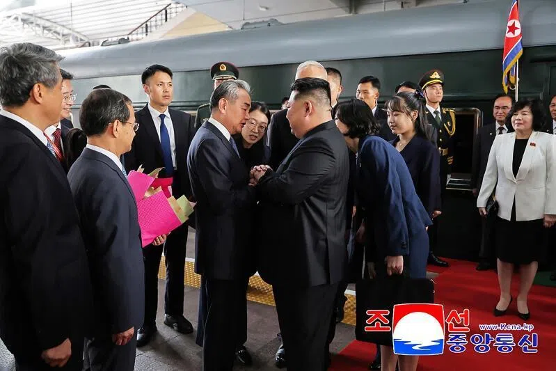 China's Foreign Minister Wang Yi (centre left) greeting North Korea's leader Kim Jong Un (centre right) at the Beijing Railway Station on Sept 2, with North Korea’s Foreign Minister Choe Son-hui (far right) looking on.
