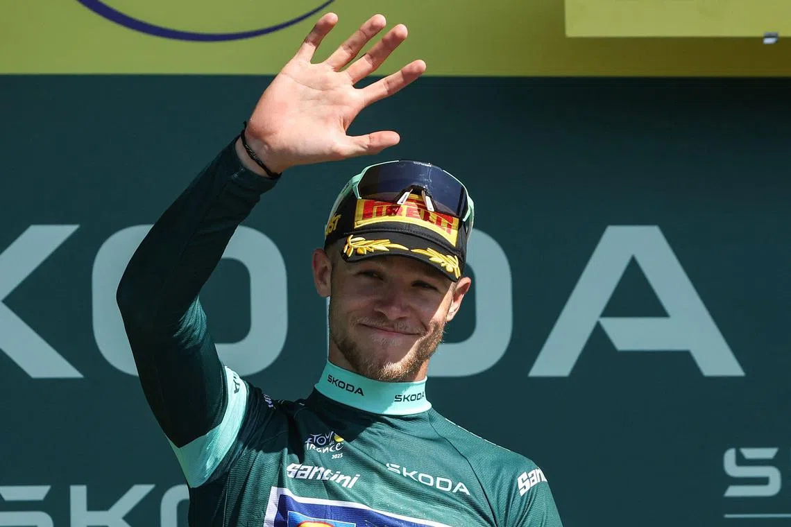 Jonathan Milan celebrates on the podium with the best sprinter's green jersey after the 8th stage of the Tour de France.