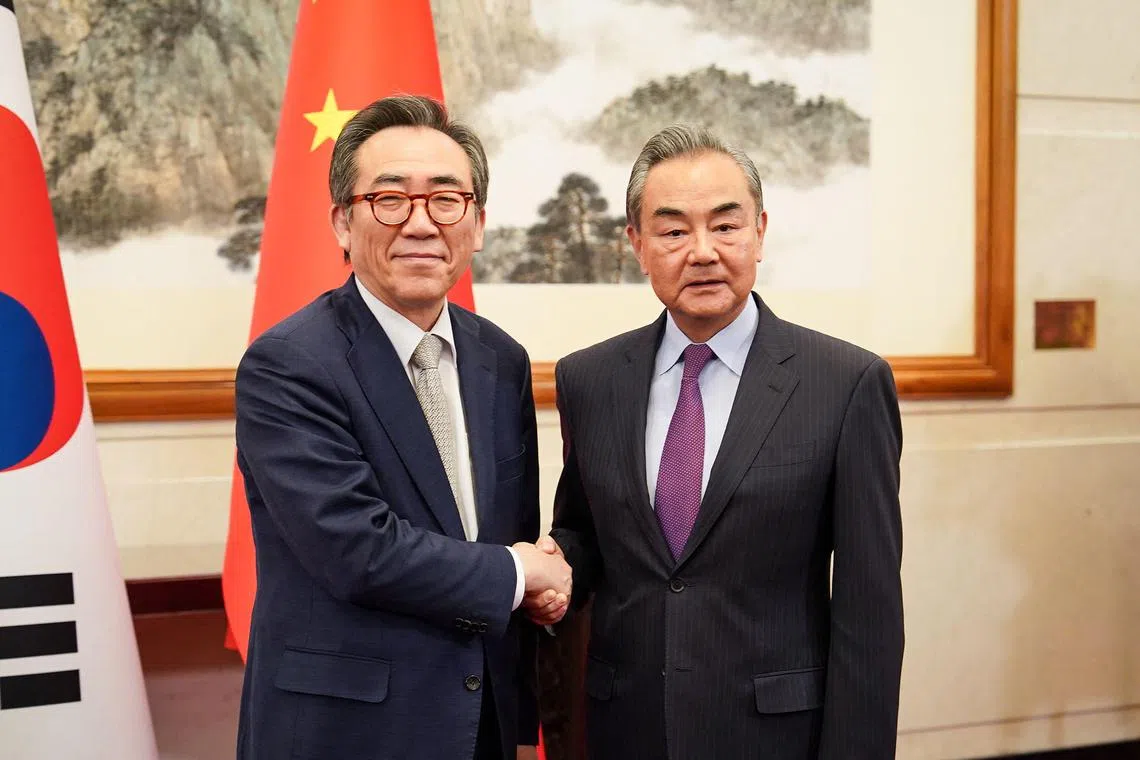 This handout photo taken on May 13, 2024 and provided by South Korean Foreign Ministry shows Chinese Foreign Minister Wang Yi (R) shaking hands with South Korea's Foreign Minister Cho Tae-yul (L) during their meeting in Beijing. (Photo by Handout / South Korean Foreign Ministry / AFP) / RESTRICTED TO EDITORIAL USE - MANDATORY CREDIT "AFP PHOTO / SOUTH KOREAN FOREIGN MINISTRY" - NO MARKETING NO ADVERTISING CAMPAIGNS - DISTRIBUTED AS A SERVICE TO CLIENTS