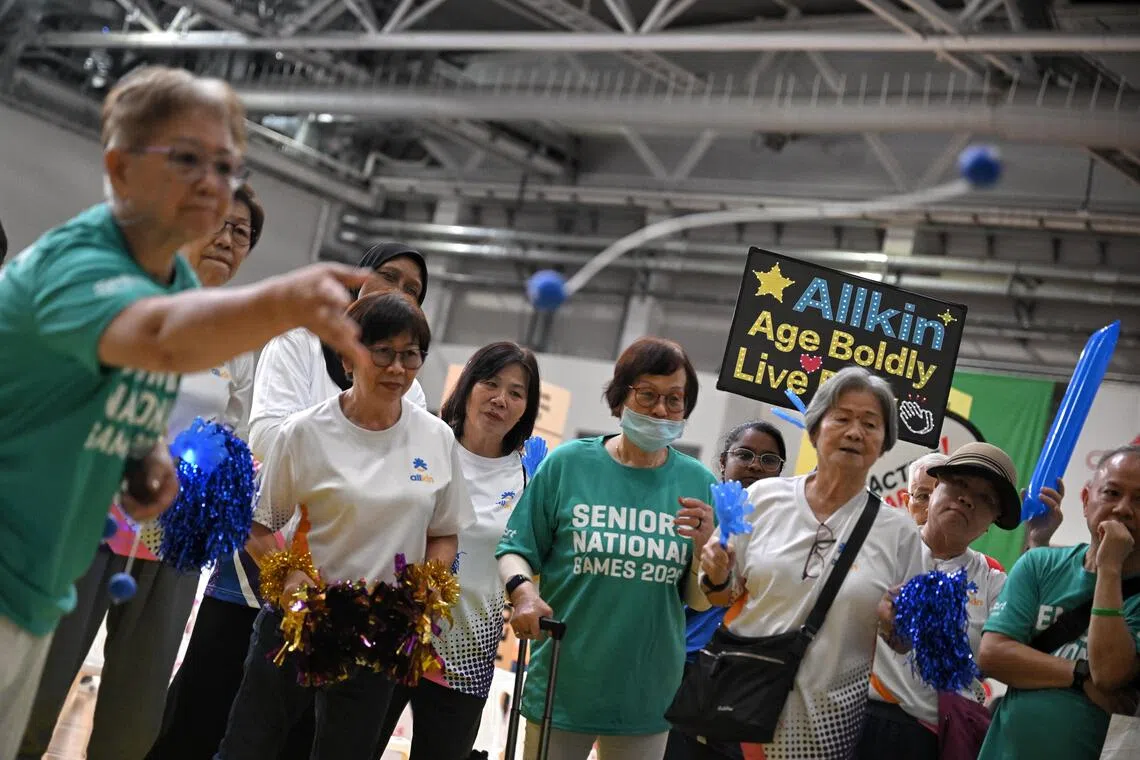 Supporters hold banners during the ladder toss segment of the Seniors National Games Finals held at the OCBC Arena on August 4, 2026.