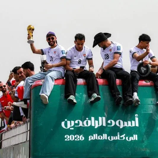 Members of Iraq's men's national football team sitting atop a double-decker bus as they are paraded with fans in Baghdad, Iraq on April 4 to celebrate the country's qualification to the 2026 FIFA World Cup.