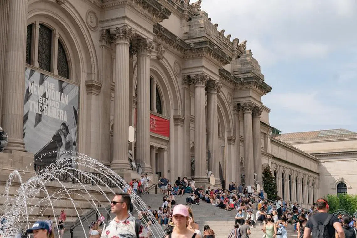 FILE PHOTO: People stand outside The Metropolitan Museum of Art in New York City, New York, U.S., July 11, 2021. REUTERS/Jeenah Moon/File Photo