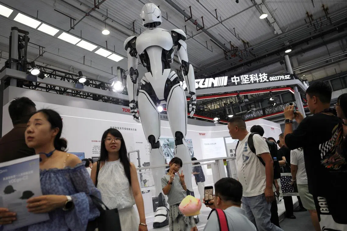 Visitors walk past a giant humanoid robot at the Topsun booth, during the 2026 World Robot Conference, in Beijing, China on Aug 21.