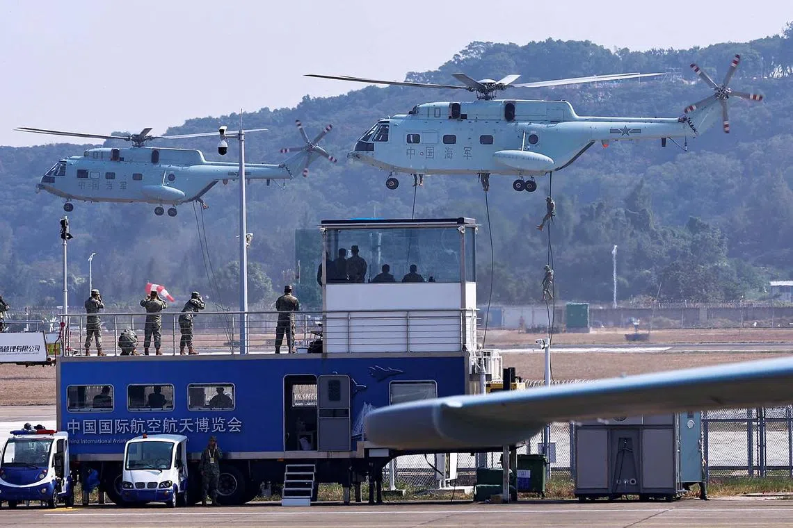 Members of the Chinese People's Liberation Army (PLA) Navy climbing off a transport helicopter at the China International Aviation and Aerospace Exhibition, also known as Airshow China, in Zhuhai, Guangdong province, China, Nov 12, 2024. 