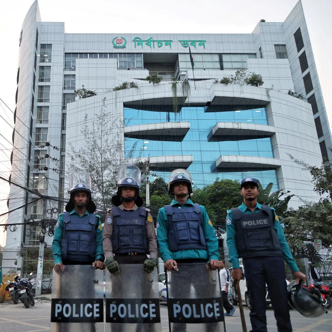 Policemen stand guard in front of the Bangladesh Election Commission office ahead of the expected general election schedule announcement in Dhaka, in December 2025.
