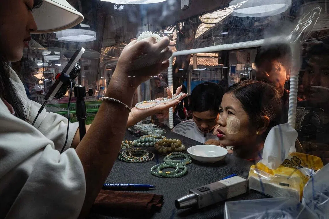 A trader inspecting bracelets at the jade market in Mandalay, Myanmar, on Jan 26, 2026. 