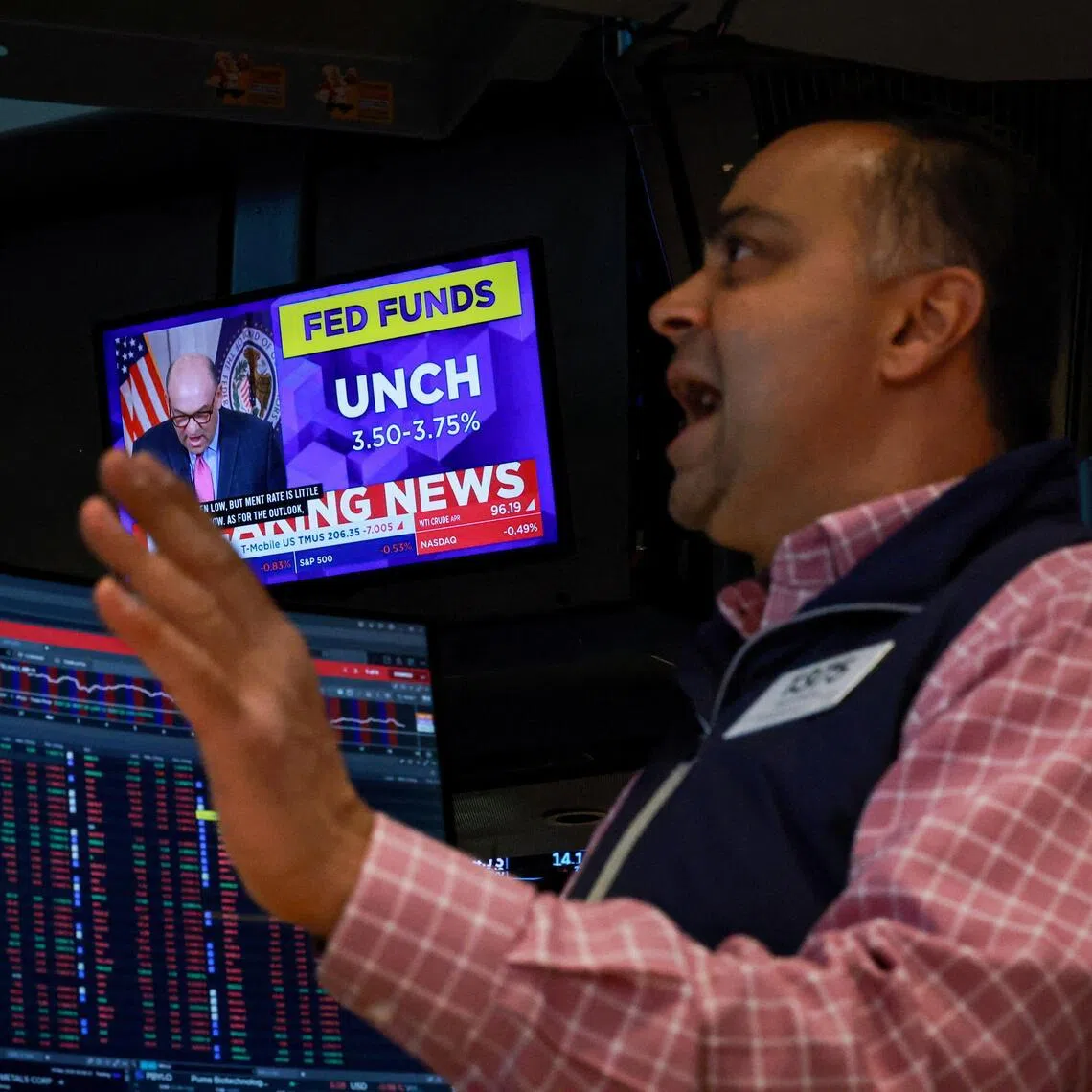 A screen displays the Fed rate announcement as a trader reacts on the floor of the New York Stock Exchange (NYSE) in New York City, U.S., March 18, 2026.  REUTERS/Brendan McDermid  