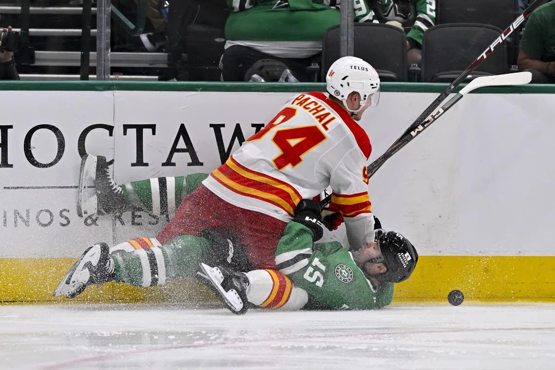 Dec 8, 2024; Dallas, Texas, USA; Calgary Flames defenseman Brayden Pachal (94) and Dallas Stars center Colin Blackwell (15) in action during the game between the Dallas Stars and the Calgary Flames at American Airlines Center. Jerome Miron-Imagn Images/File Photo