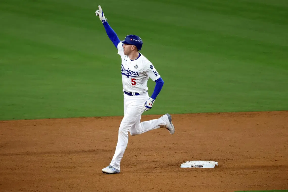 Oct 25, 2024; Los Angeles, California, USA; Los Angeles Dodgers first baseman Freddie Freeman (5) celebrates as he runs after hitting a grand slam home run in the tenth inning against the New York Yankees during game one of the 2024 MLB World Series at Dodger Stadium. Mandatory Credit: Kiyoshi Mio-Imagn Images