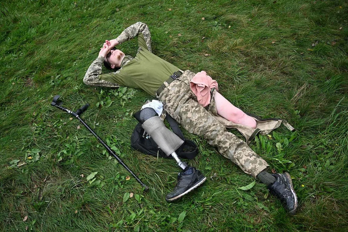 Ukrainian serviceman Andriy, 20, an amputee, rests after climbing Mount Klyuch, near the village of Trukhaniv, Lviv region, on Sept 16.