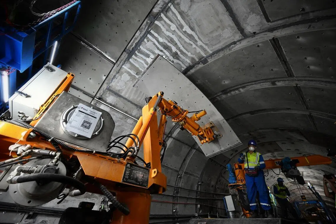The robotic arm lifts the plate to the tunnel wall and holds it in position while engineers work on securing it.