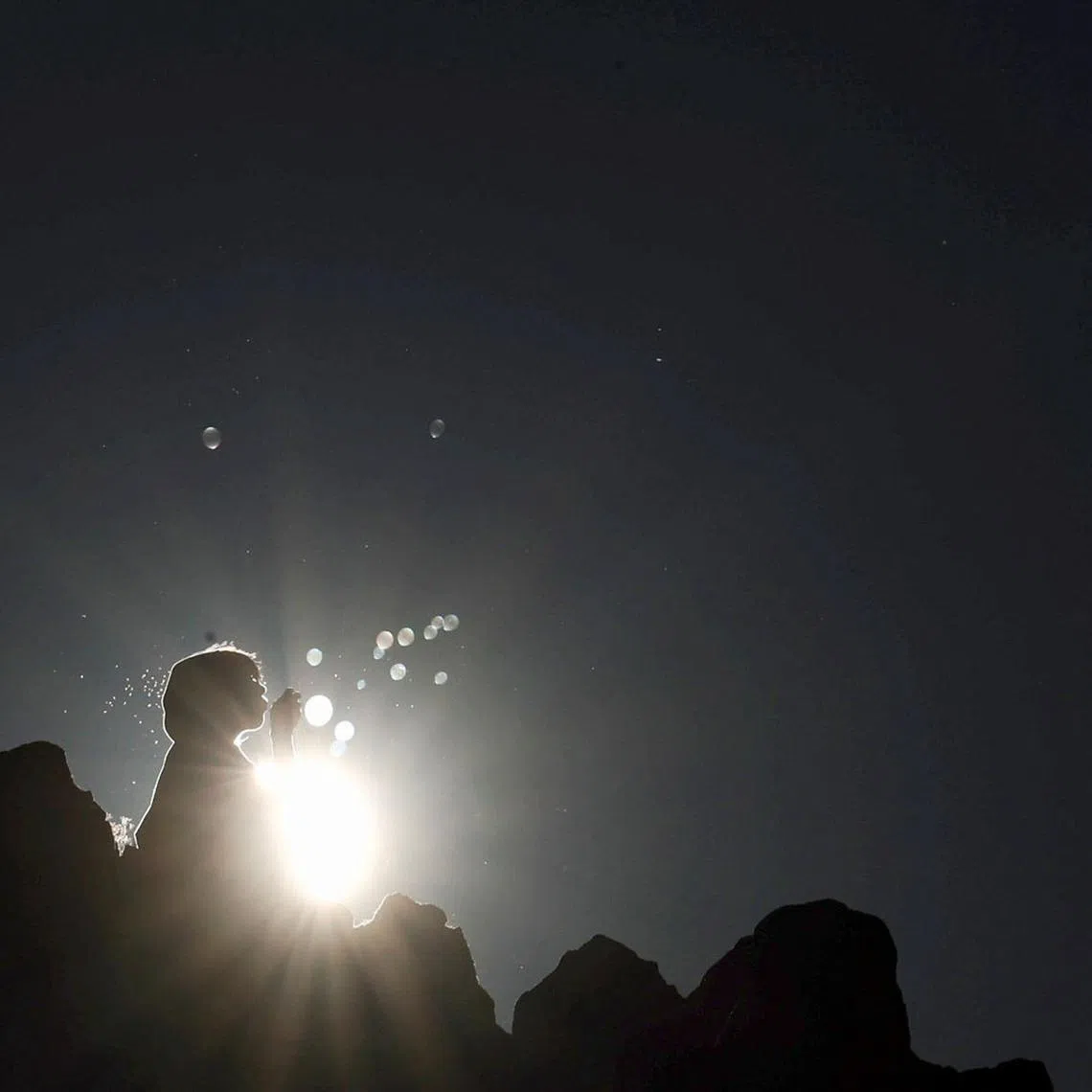 A girl blowing soap bubbles while celebrating the summer solstice at the Kokino Megalithic Observatory in North Macedonia, on June 21.
