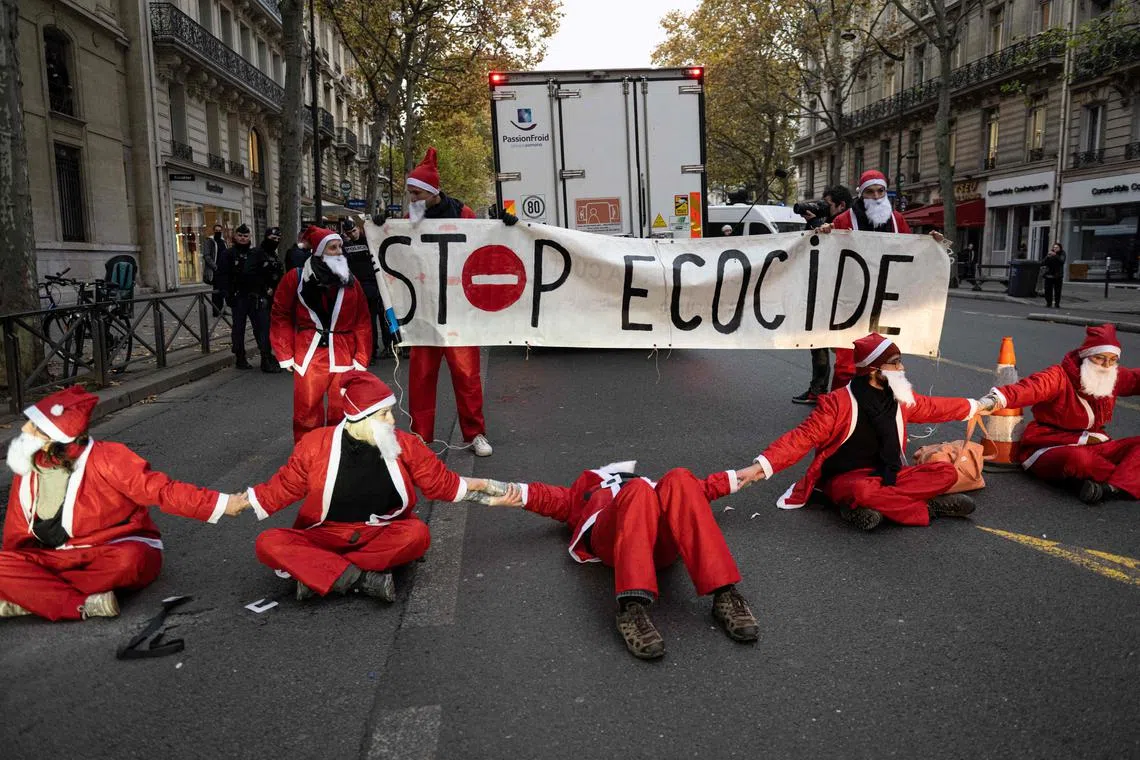 Extinction Rebellion activists sit on the Boulevard Saint-Germain in Paris, on Dec 6, 2022.