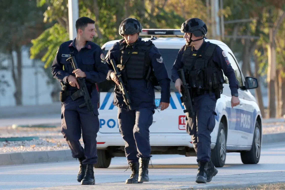 Armed Turkish officers patrolling close to the gate of Turkish Aerospace Industries, on Oct 23, after an attack left a number of people "dead and injured".