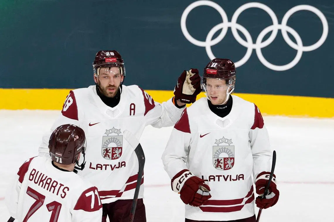 Milano Cortina 2026 Olympics - Ice Hockey - Men's Preliminary Round - Group C - Germany vs Latvia - Milano Rho Ice Hockey Arena, Milan, Italy - February 14, 2026. Dans Locmelis of Latvia celebrates scoring their second goal with Zemgus Girgensons and Roberts Bukarts REUTERS/David W Cerny