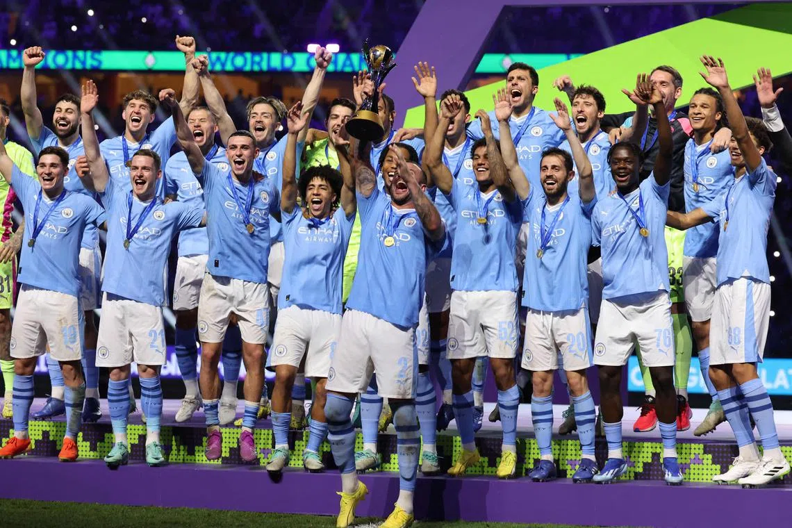 Manchester City players celebrate with the winner's trophy