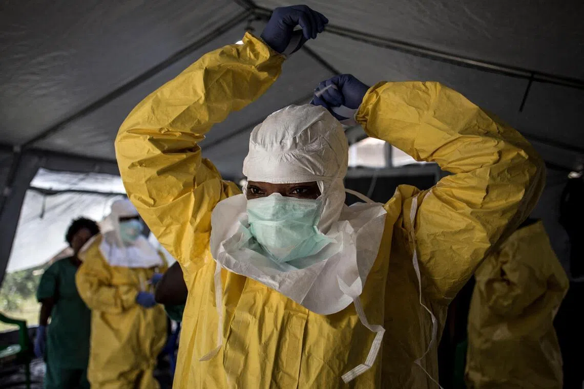 A medical worker puts on her Personal Protective Equipment (PPE) ahead of entering an Ebola Treatment Centre run by The Alliance for International Medical Action (ALIMA) on Aug 12, 2018, in Beni. 