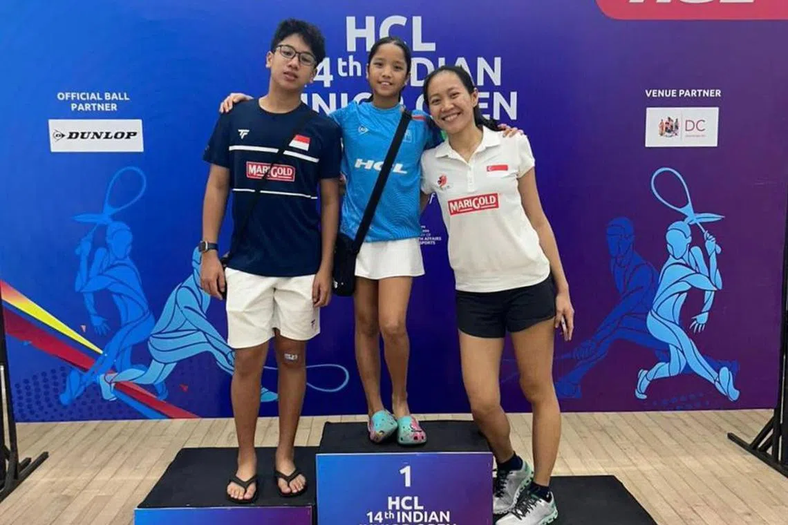 Singapore squash player Kareena Sashikumar (centre) with her brother Jackrish Sashikumar and coach Gillian Ng.
