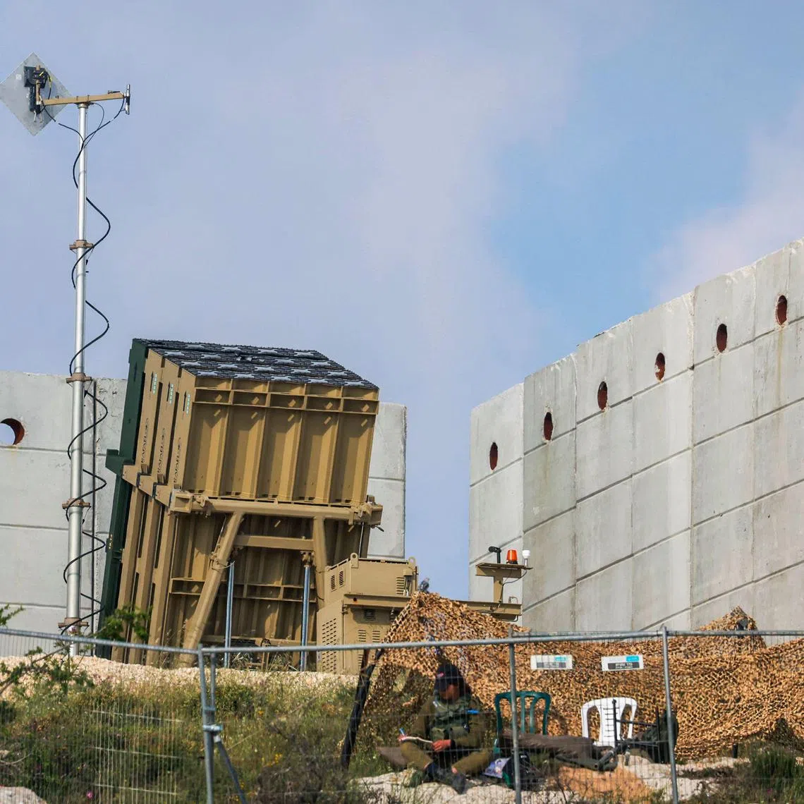 An Israeli soldier takes up a position in front of a battery of an Iron Dome air defence system near Jerusalem on April 15.