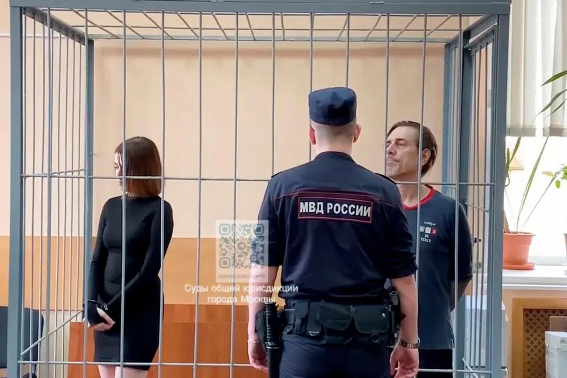 Russian Veronika Grabanchuk and American Michael Travis Leake, both convicted of drug smuggling, stand inside a court cage.
