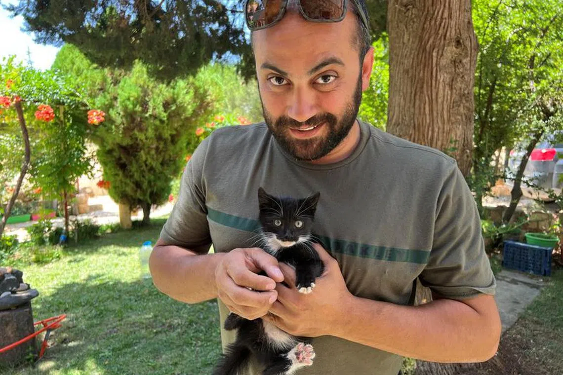Reuters' journalist Issam Abdallah holds a kitten while posing for a picture in Saaideh, Lebanon, July 4, 2023. REUTERS/Emilie Madi