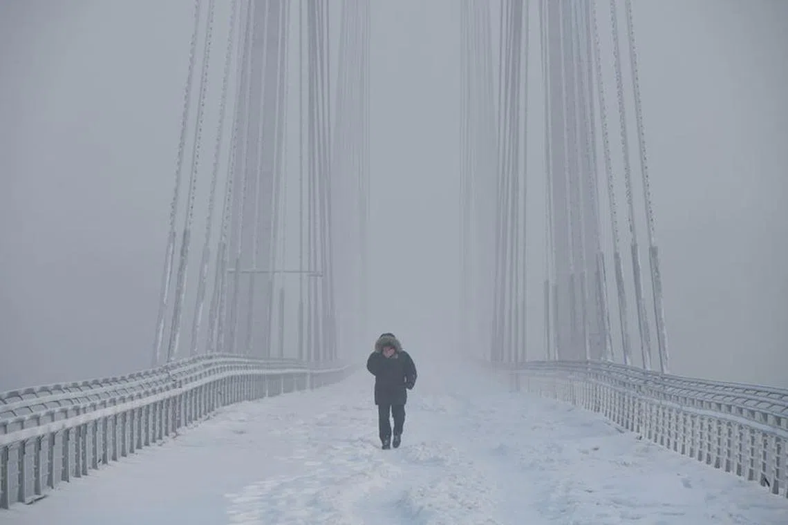 A man walks on the Vinogradovsky Bridge across the Yenisei River, as the air temperature plunges as low as minus 35 degrees Celsius (minus 31 degrees Fahrenheit), in the Siberian city of Krasnoyarsk, Russia, December 12, 2023. REUTERS/Alexander Manzyuk/ File photo