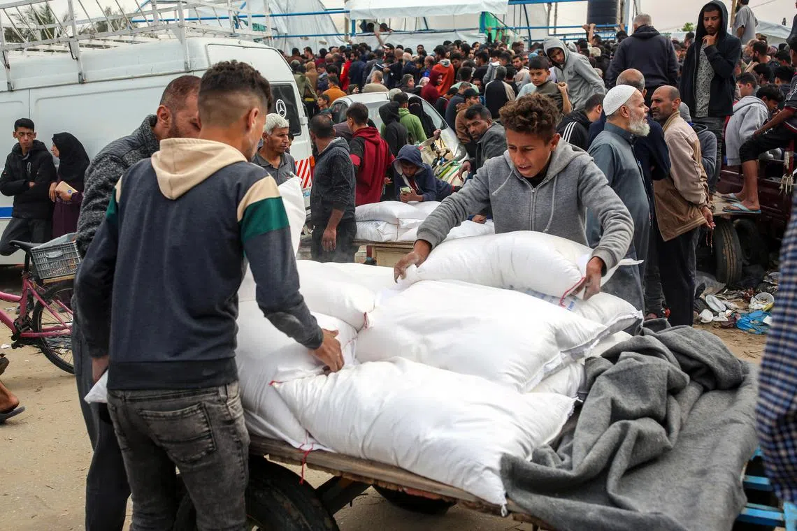 UNRWA staff distribute flour at its headquarters in Khan Younis, in the southern Gaza Strip.