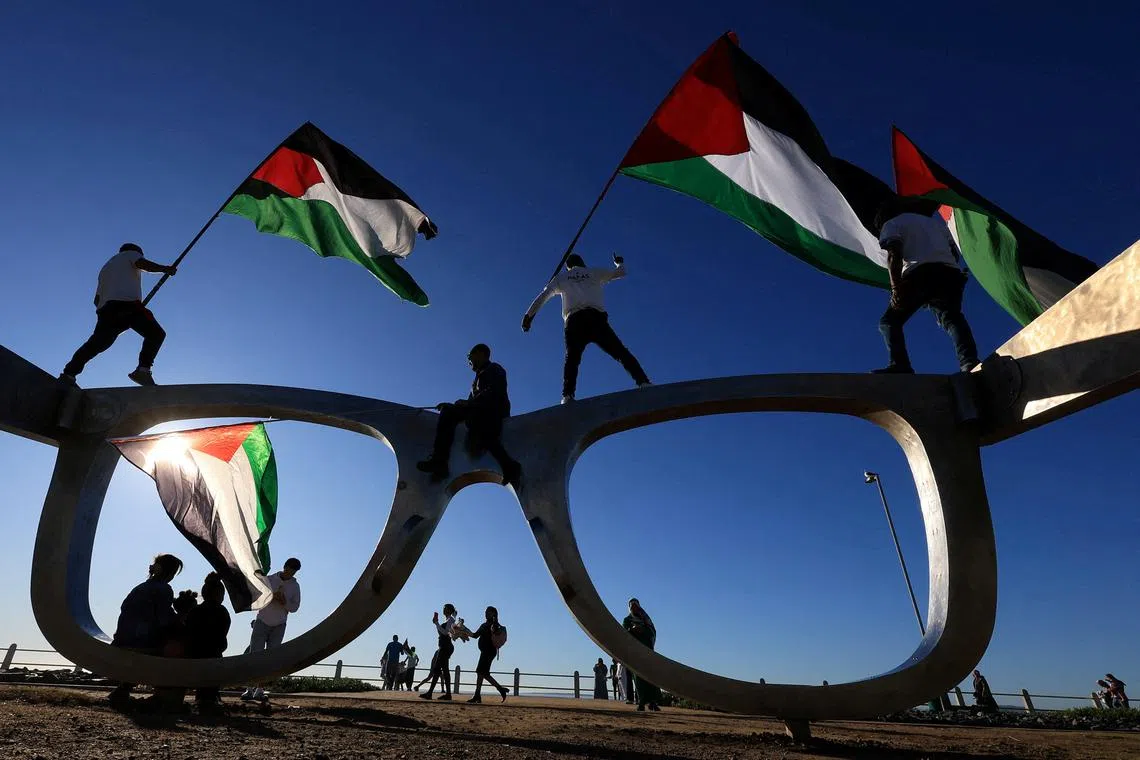 Pro-Palestinian activists holding Palestinian flags as they protest over hunger crisis in Gaza, along Sea Point Promenade in Cape Town, South Africa, July 27, 2025. 
