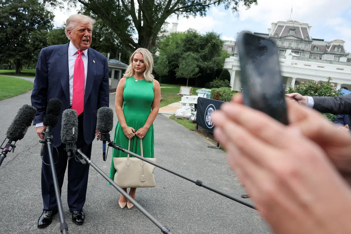 FILE PHOTO: U.S. President Donald Trump speaks with reporters, while White House Press Secretary Karoline Leavitt stands next to him, as he departs for travel to Pennsylvania from the South Lawn at the White House in Washington, D.C. U.S., July 15, 2025. REUTERS/Jonathan Ernst/File Photo