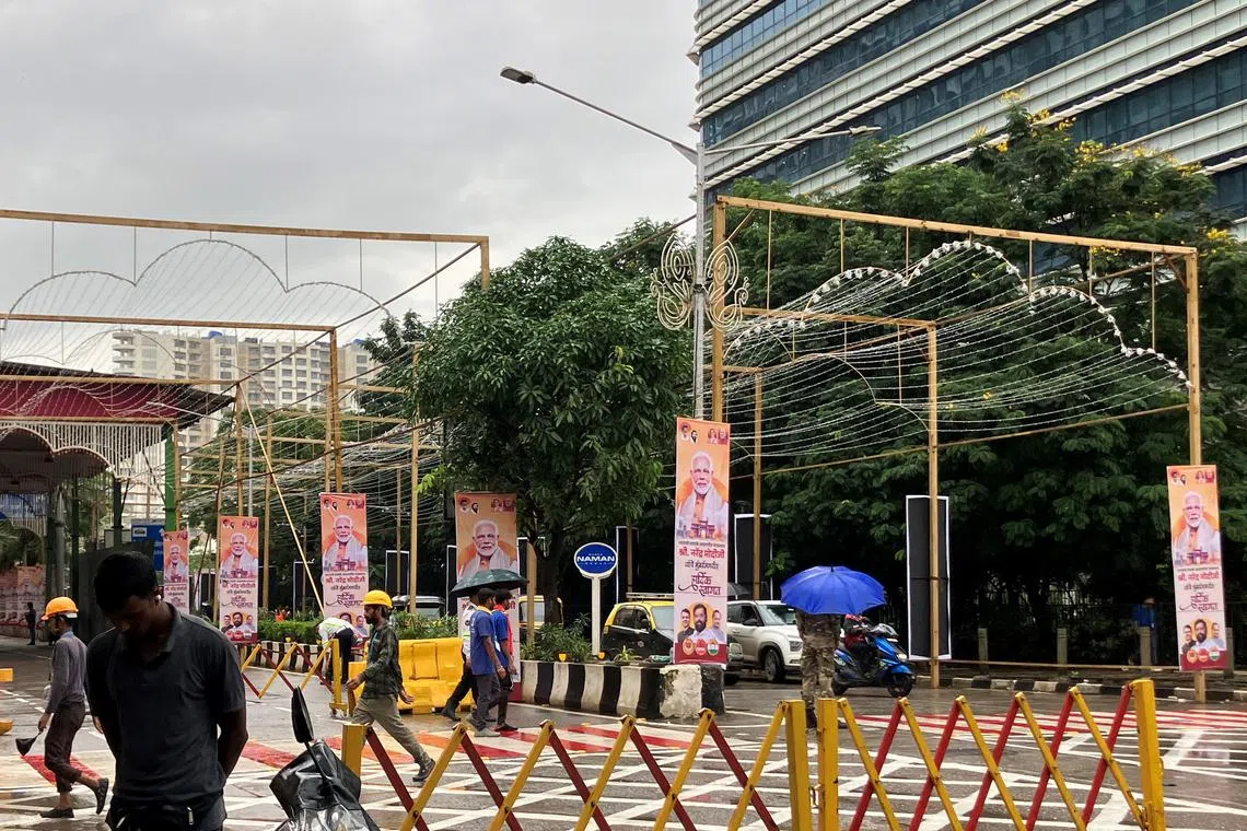 People walk past posters of India's Prime Minister Narendra Modi outside Jio World Convention Centre, the wedding venue of Anant Ambani, son of Indian billionaire Mukesh Ambani, in Mumbai, India, July 12, 2024. REUTERS/Dhwani Pandya