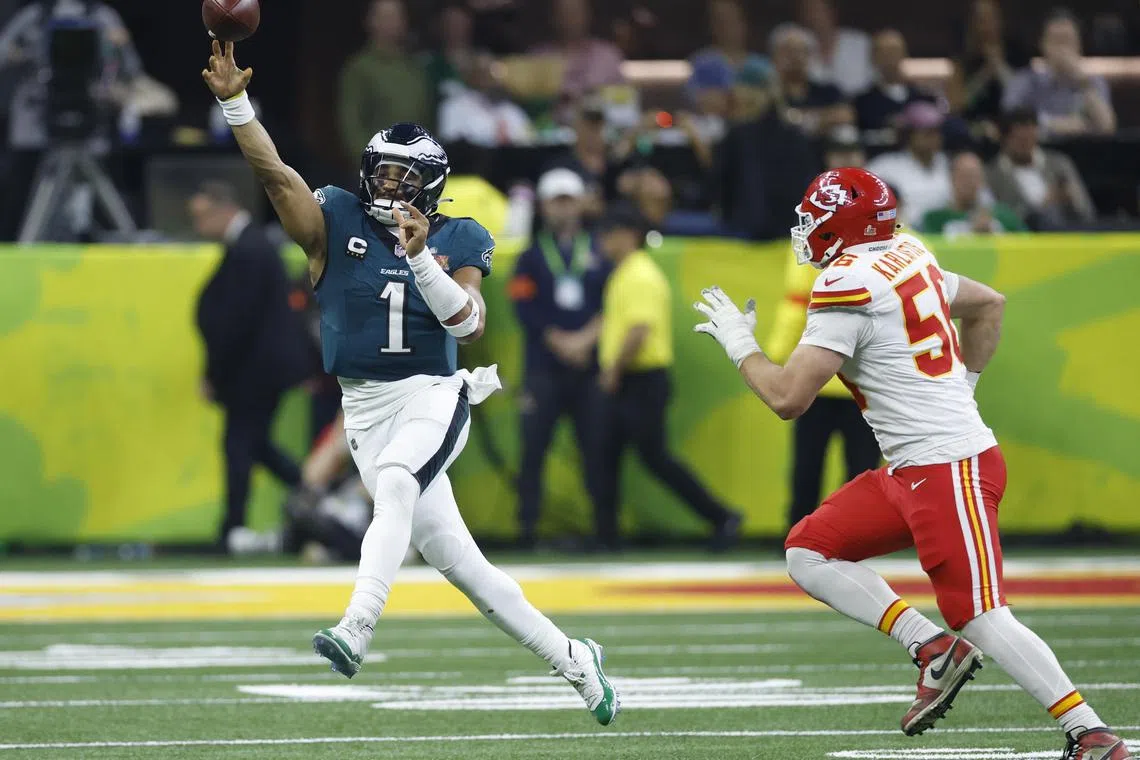 Philadelphia Eagles quarterback Jalen Hurts, left, launches another pass during his brilliant performance in the Super Bowl.