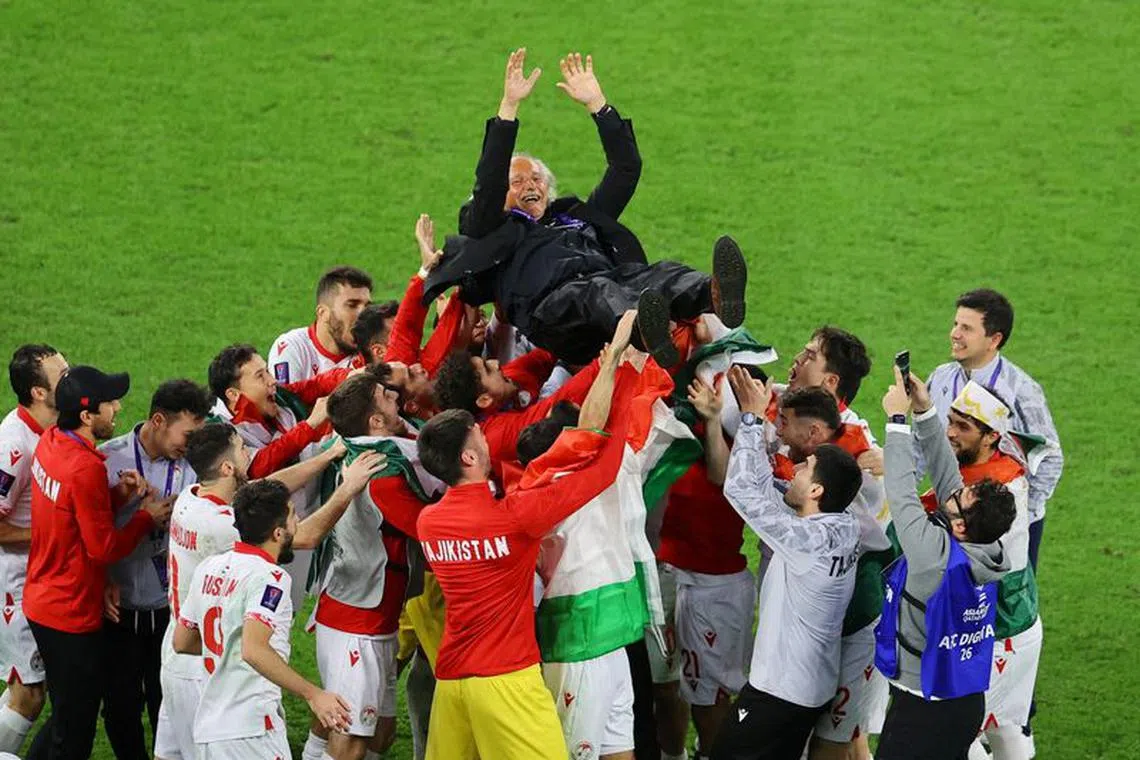 Soccer Football - AFC Asian Cup - Round of 16 - Tajikistan v United Arab Emirates - Ahmad bin Ali Stadium, Al Rayyan, Qatar - January 28, 2024 Tajikistan players celebrate with coach Petar Segrt after the match REUTERS/Ibraheem Al Omari