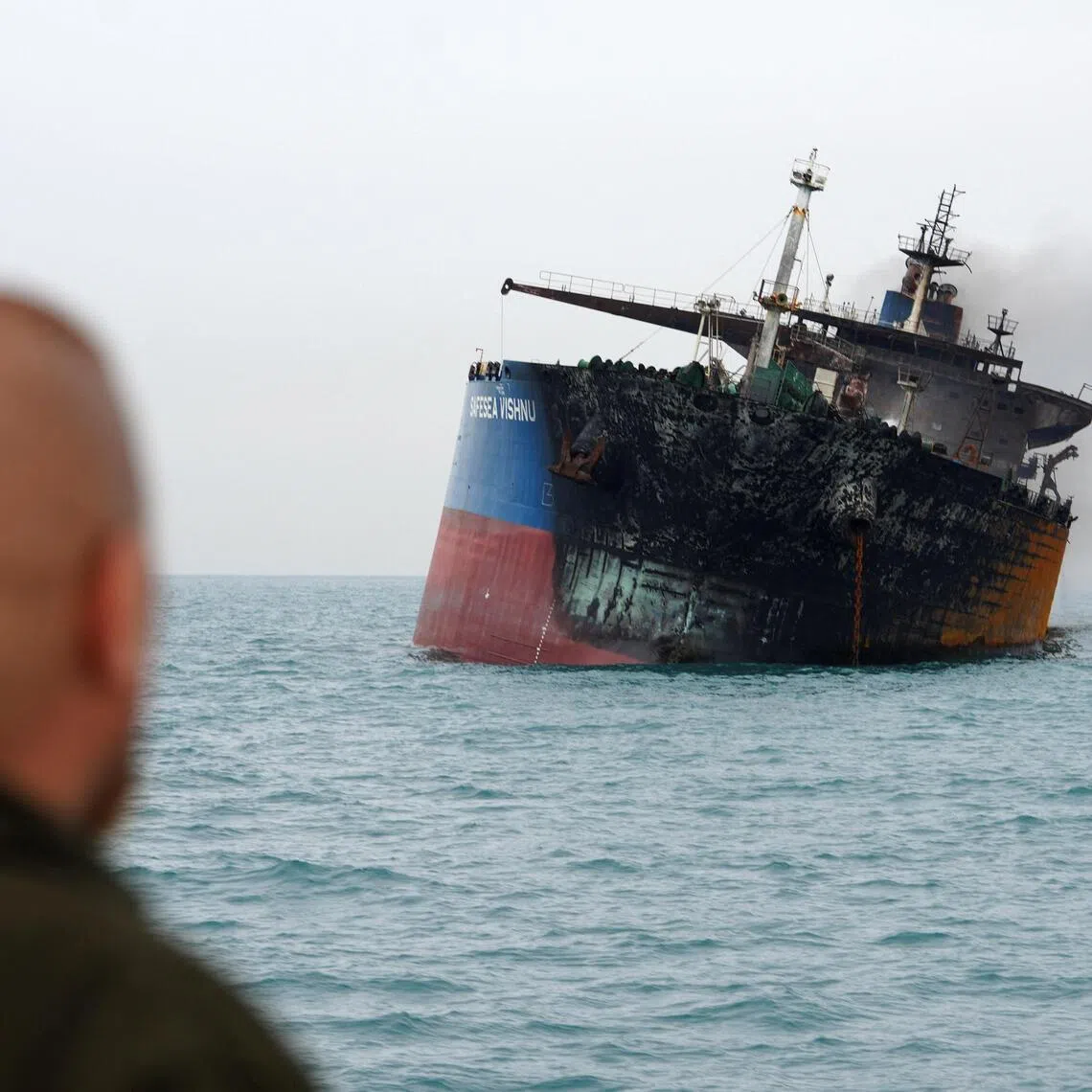 An oil tanker is seen listing to one side after it was attacked and set ablaze off Iraq’s coast.
